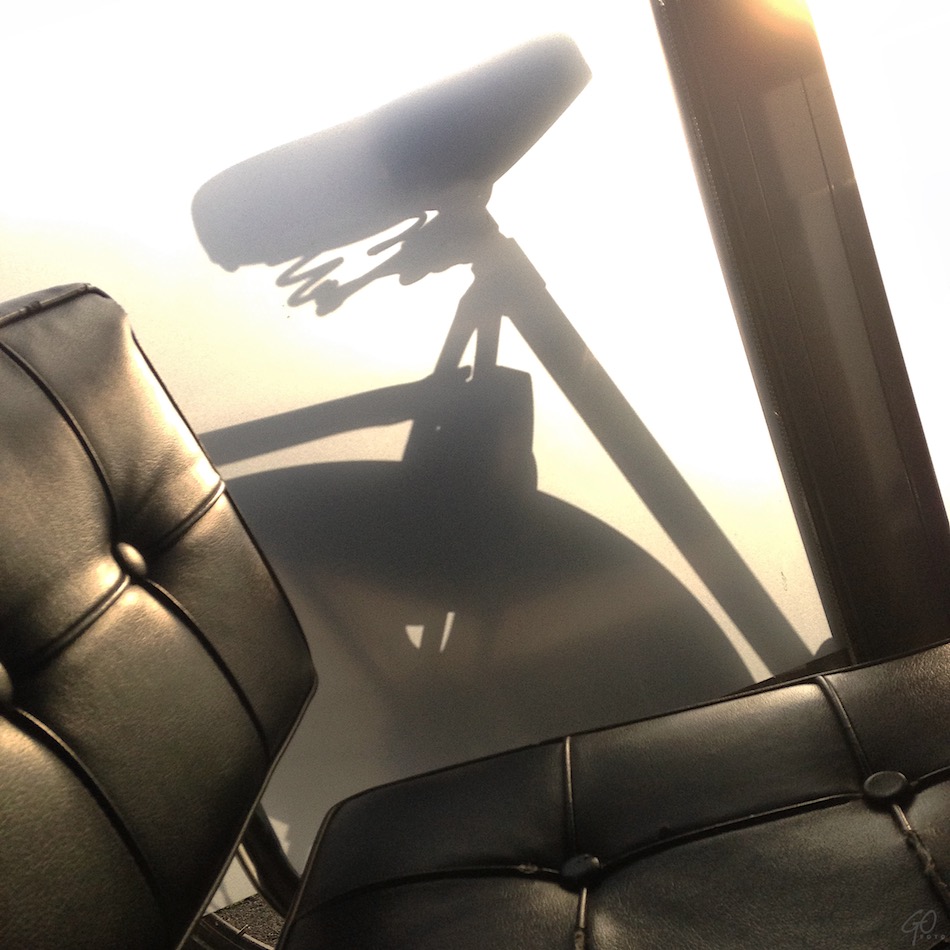 Een foto met fel tegenlicht. Je ziet een stoel en de contouren van een fietszadel. iPhonefotografie.